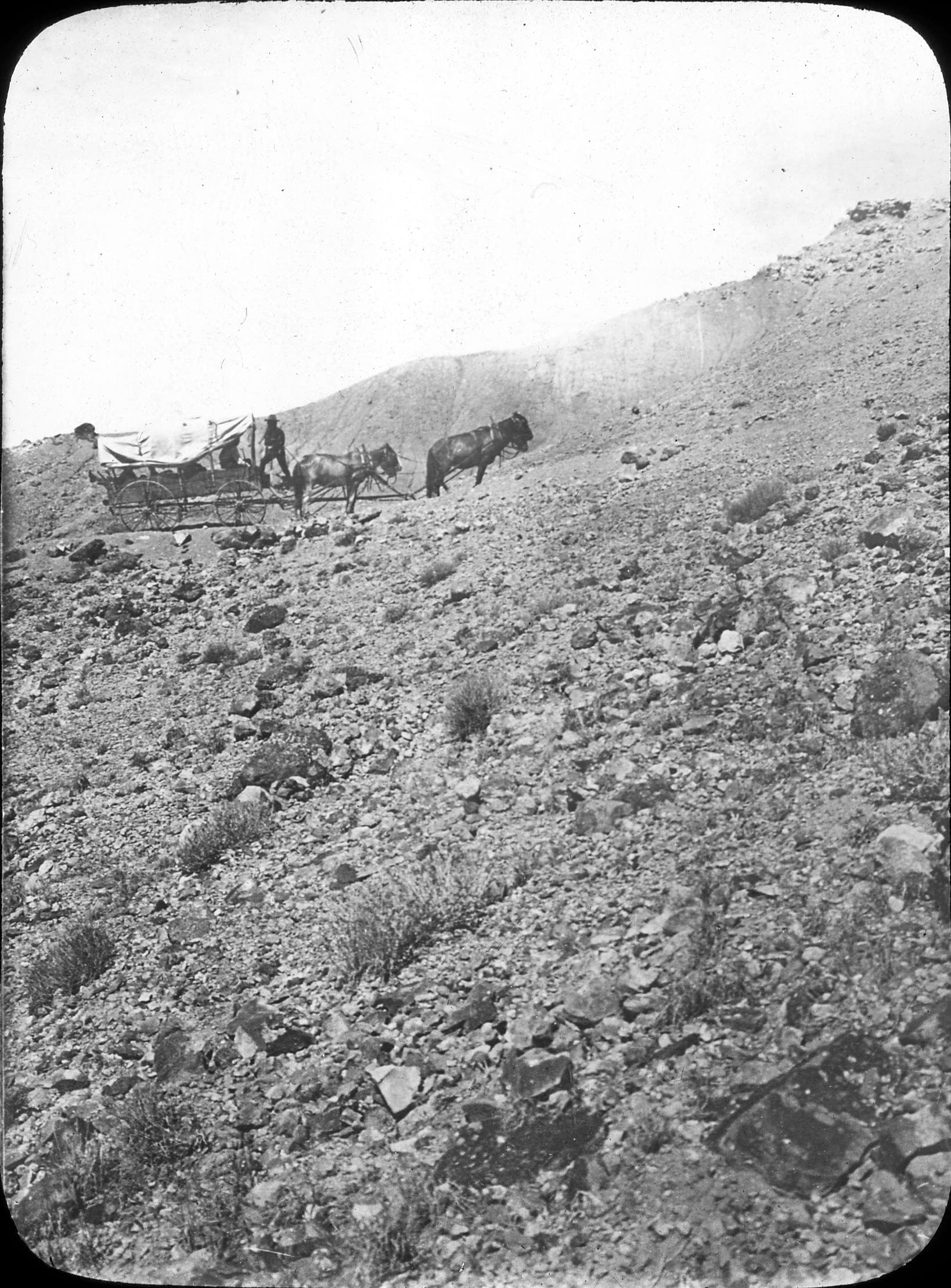 A prairie schooner wagon crossing rough country in an archival photograph.